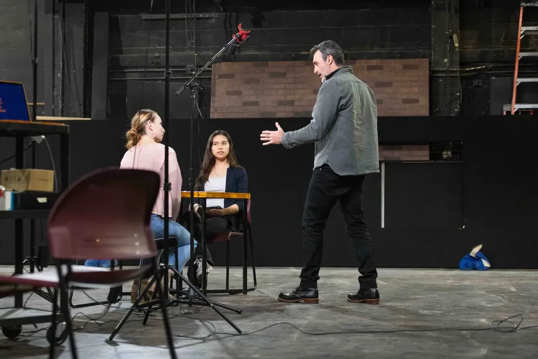 校友 Reid Scott standing on a stage with students.